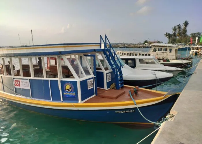 Bateau de plongée amarré au port avec des marquages et logos visibles
