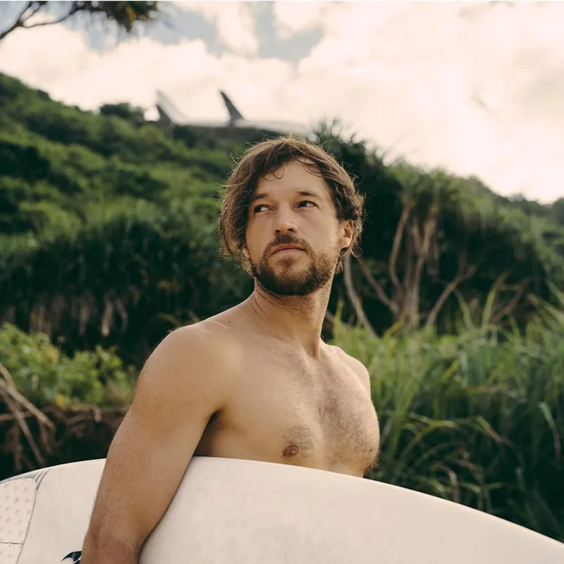 Portrait d'un homme torse nu regardant au loin avec une planche