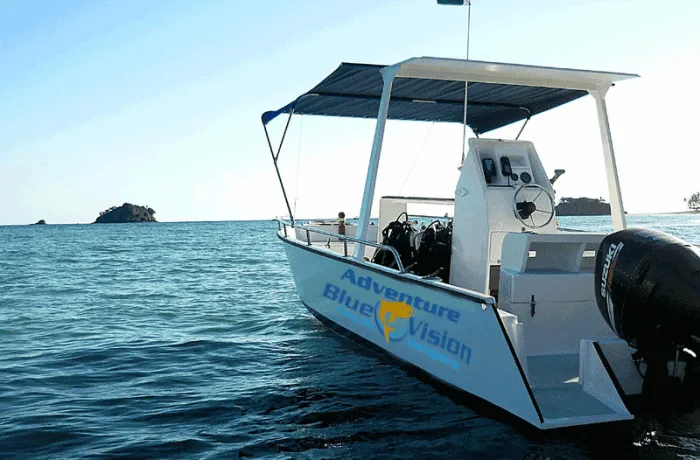 Bateau de plongée blanc sur l'eau avec une personne à bord