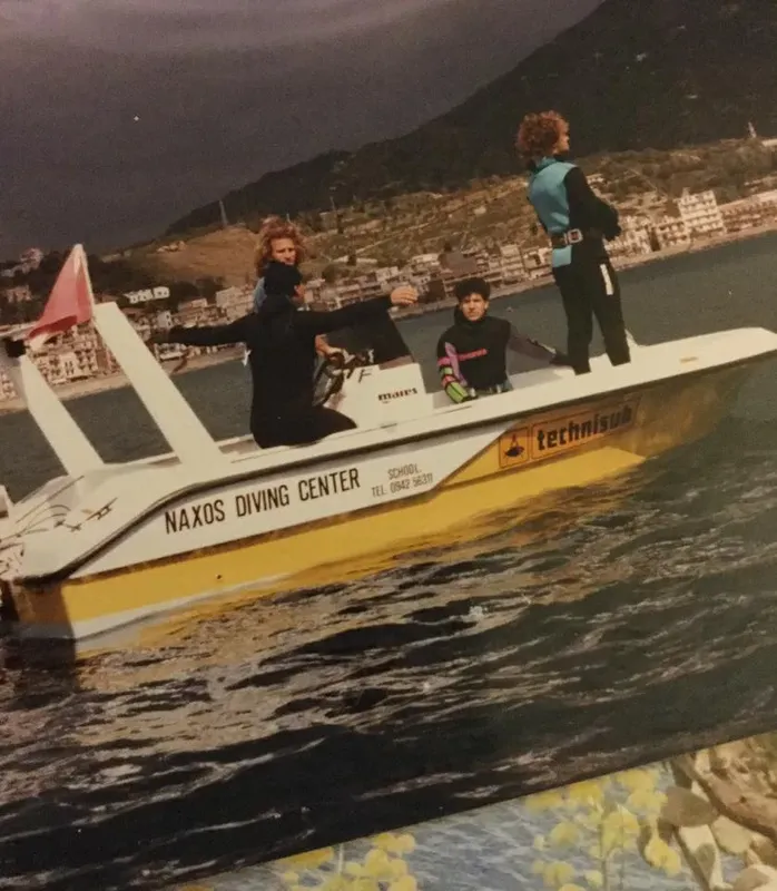 Trois personnes à bord d'un bateau de plongée jaune et blanc