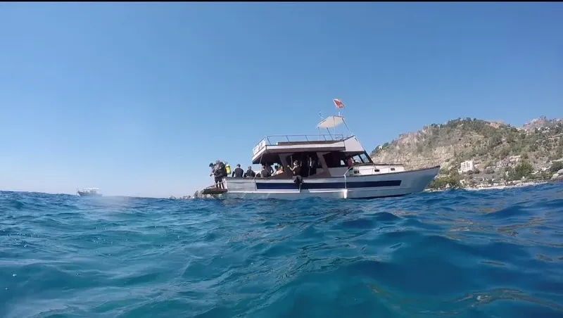 Vue sous-marine d'un bateau avec des plongeurs à bord en mer