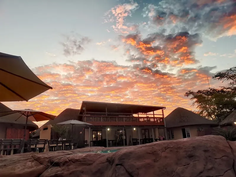 Bâtiments du centre de plongée avec un ciel orangé au coucher du soleil