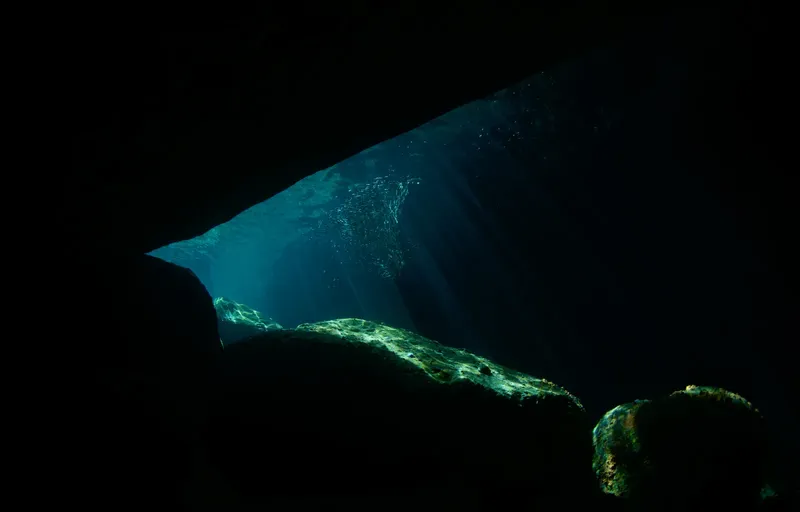 Ouverture sous-marine vers la lumière, récif rocheux et bulles