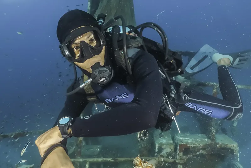 Plongeur souriant avec équipement complet explore une épave sous-marine