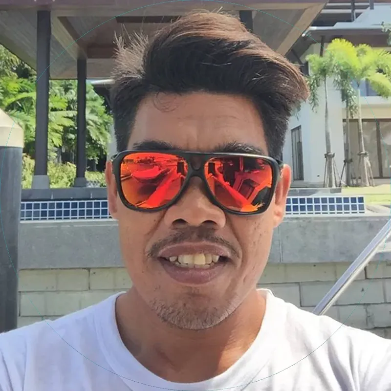 Portrait d'un homme souriant avec des lunettes de soleil oranges