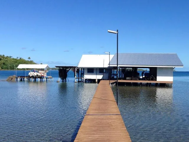 Structures sur pilotis au-dessus de l'eau, ponton en bois et ciel bleu