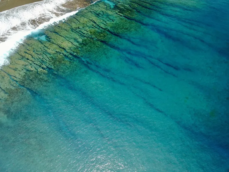 Vue aérienne d'une côte rocheuse avec des eaux turquoise et claires