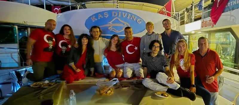 Groupe de personnes souriantes sur le pont d'un bateau de plongée