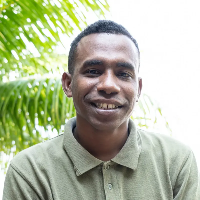 Portrait souriant d'un homme à la peau mate et au polo vert