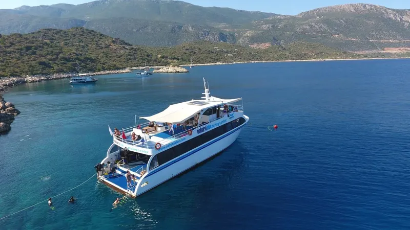 Bateau de plongée en mer avec des personnes à bord et paysage côtier