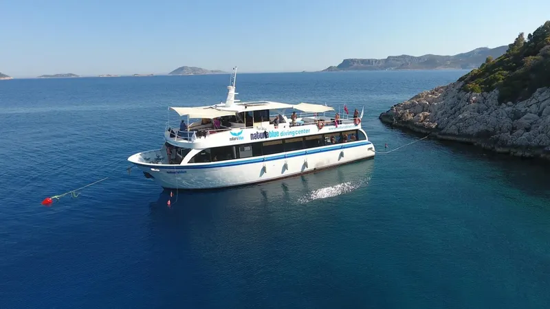 Grand bateau de plongée blanc navigue sur une mer bleue claire