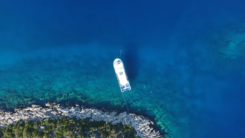 Vue aérienne d'un bateau de plongée au-dessus d'un fond marin rocheux