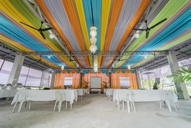 Salle de cours ou reception decorée avec des tissus colorés et ventilateurs