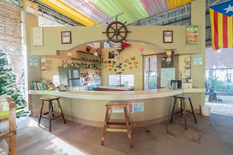 Bar coloré avec comptoir incurvé, tabourets et décoration marine