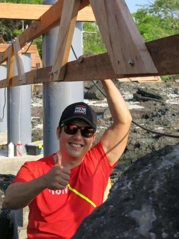 Homme souriant avec casquette et lunettes de soleil, pouce levé
