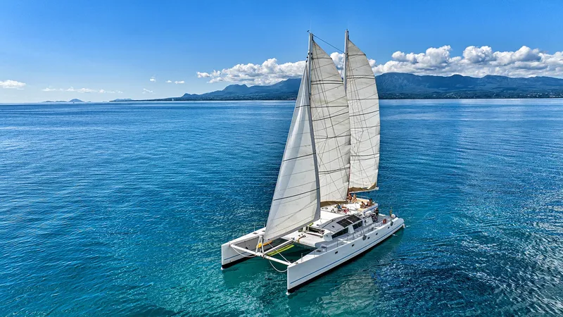 Catamaran à voile naviguant sur une mer bleue avec des passagers