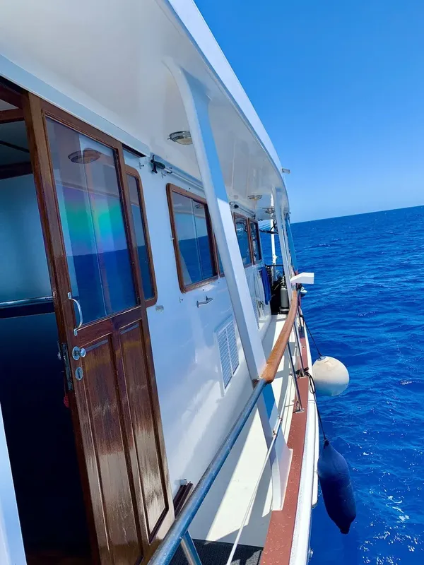 Bateau de plongée blanc avec des fenêtres ouvertes sur une mer bleue