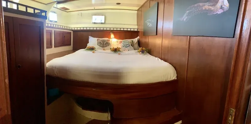 Intérieur de cabine de bateau avec grand lit rond et décoration florale