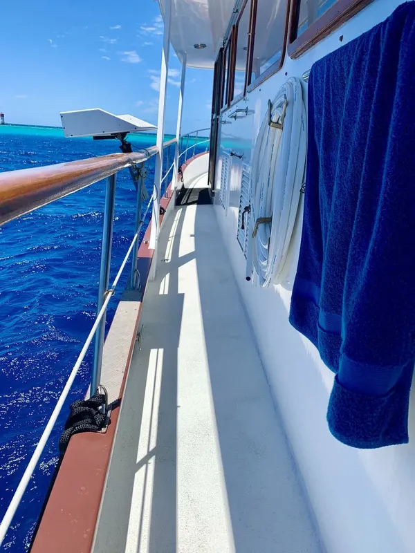 Bateau de plongée en mer, vue latérale avec garde-corps et eau bleue