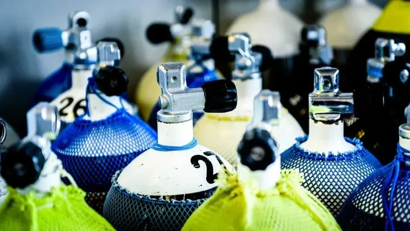 Bouteilles de plongée bleues et blanches avec protections en filet jaune