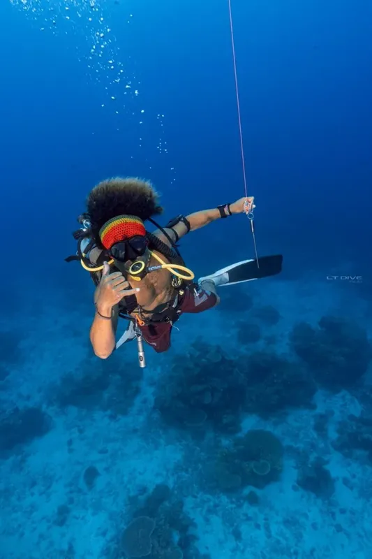 Plongeur en apnée, geste de silence, bleu profond, exploration sous-marine