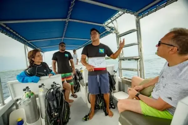 Groupe de plongeurs écoute un instructeur sur un bateau en mer