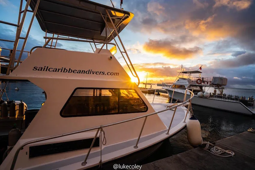 Bateaux de plongée amarrés au port au coucher du soleil doré