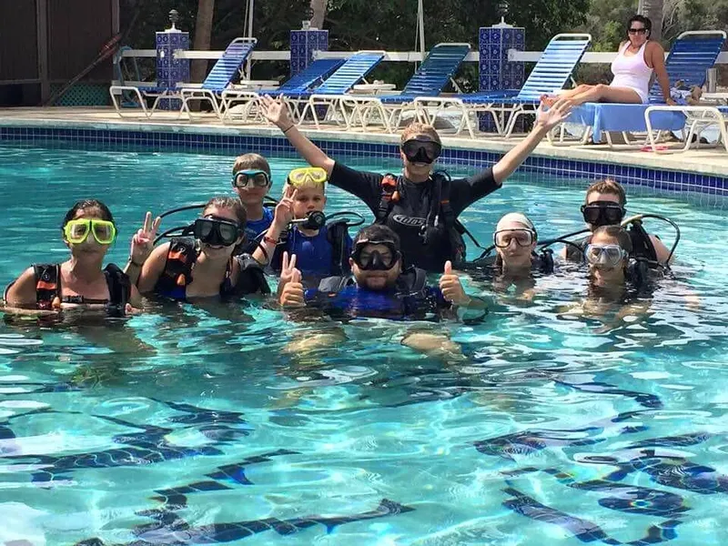 Groupe de personnes en combinaison de plongée dans une piscine