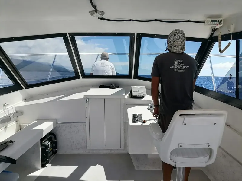 Intérieur d'un bateau de plongée avec deux personnes regardant l'horizon