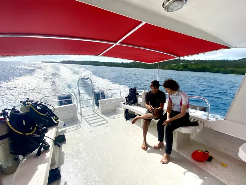 Deux plongeurs sur un bateau en mer, équipement visible