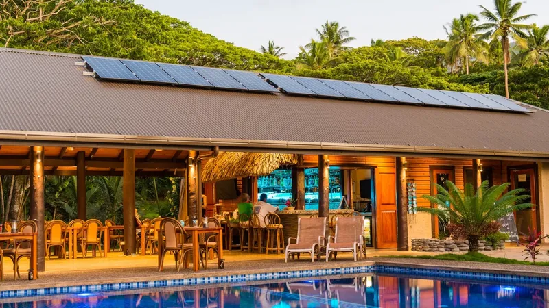 Terrasse d'un bar avec piscine et végétation tropicale en arrière-plan