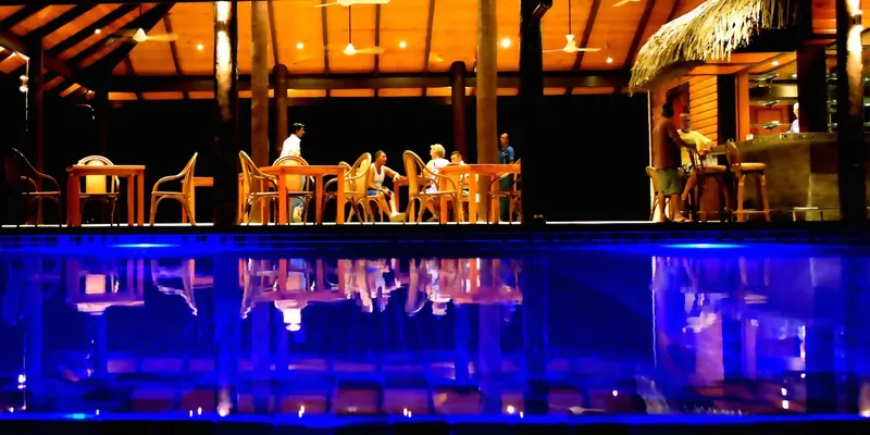 Terrasse en bois avec tables, chaises et comptoir de bar éclairés