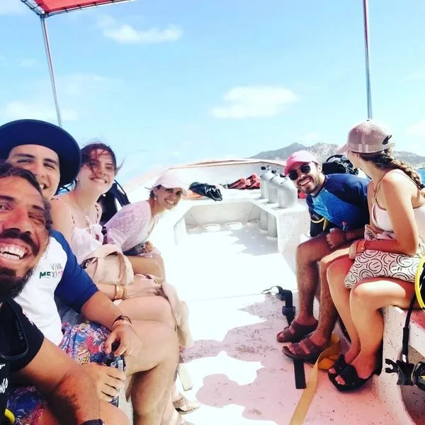 Groupe de plongeurs souriants à bord d'un bateau en mer