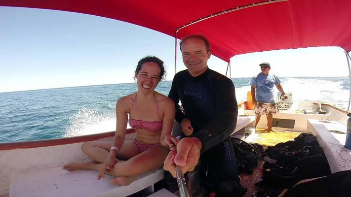 Deux personnes souriantes sur un bateau de plongée en mer