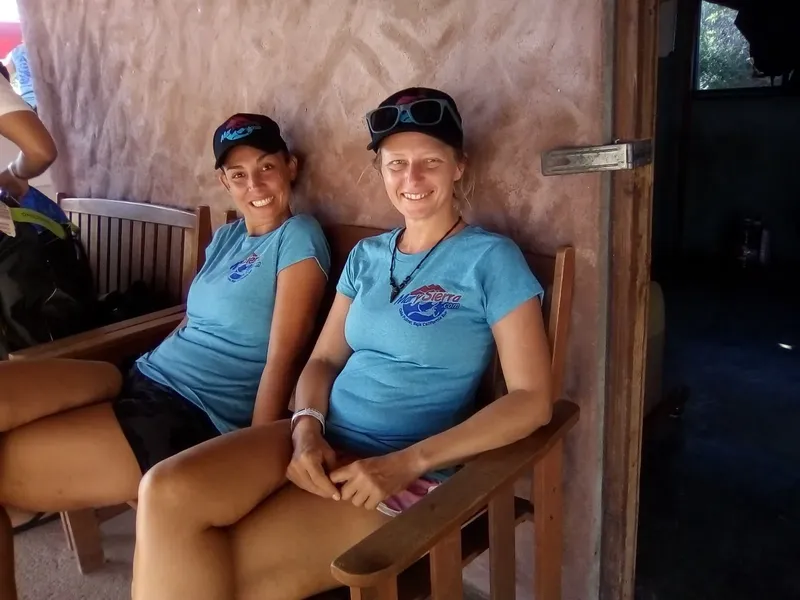 Deux femmes souriantes assises sur un banc en bois