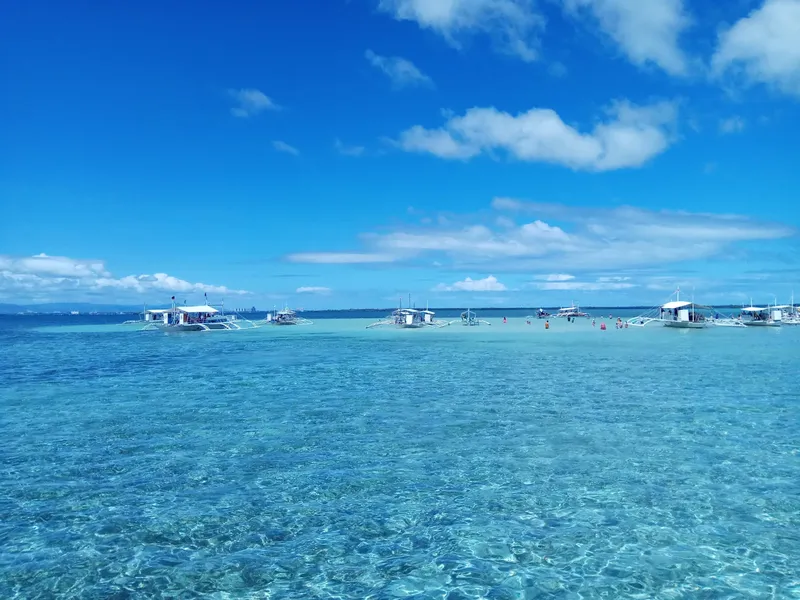Plusieurs bateaux de pêche traditionnels sur une eau turquoise claire