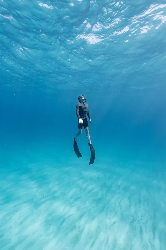 Apnée : un plongeur en équilibre dans une eau turquoise claire