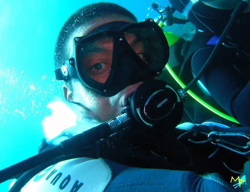 Plongeur avec masque et détendeur, regardant la caméra sous l'eau