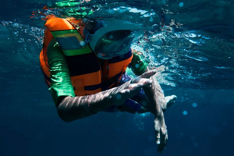 Personne nageant sous l'eau avec un masque intégral et un gilet