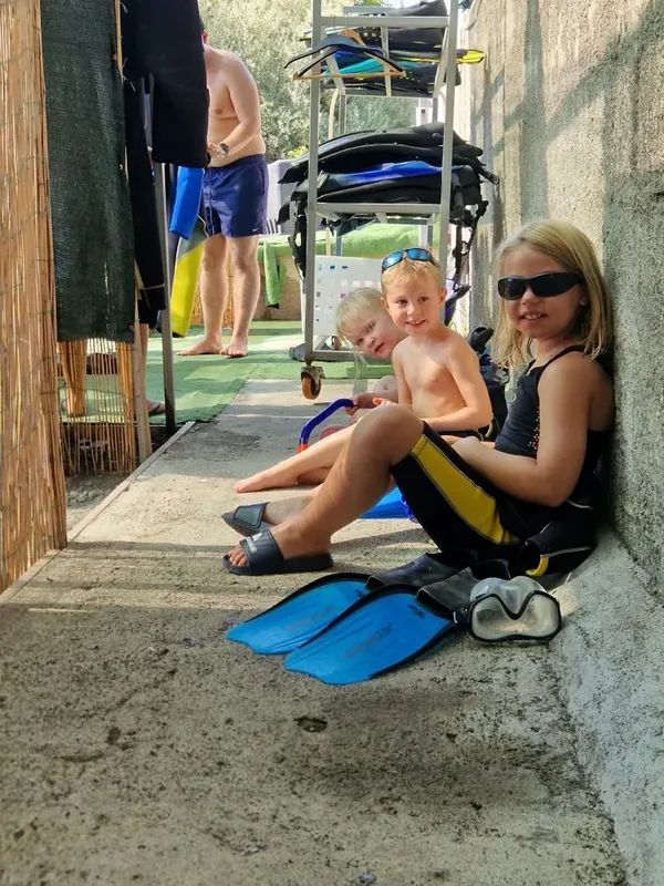 Trois enfants souriants avec palmes et masques de plongée au soleil
