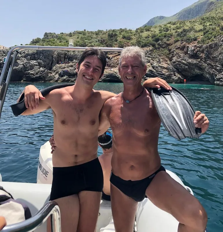Deux hommes souriants sur un bateau avec palmes et masque