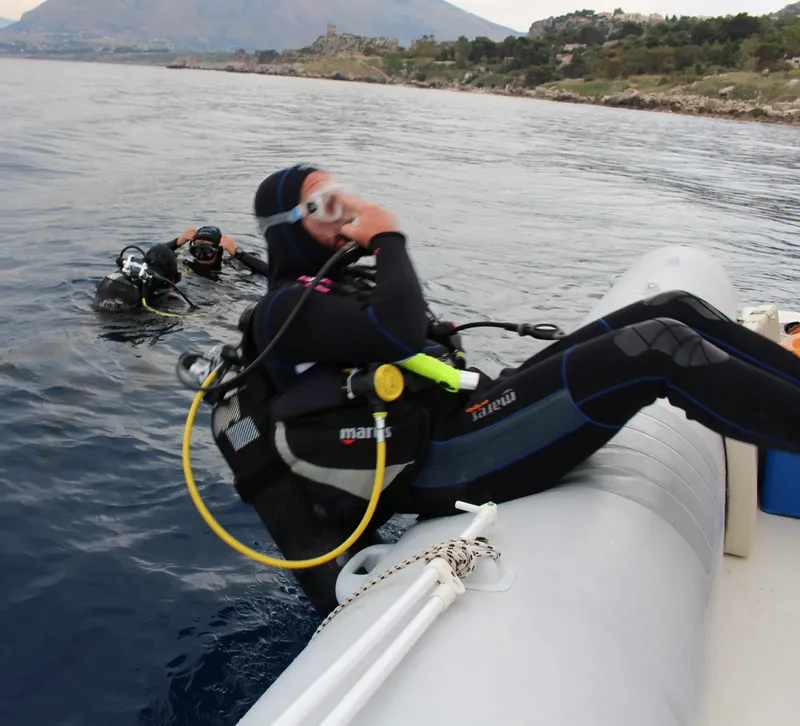 Plongeurs préparant leur matériel à bord d'un bateau pneumatique en mer