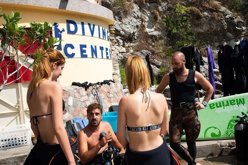 Plongueurs se preparant sur un quai devant le centre de plongee