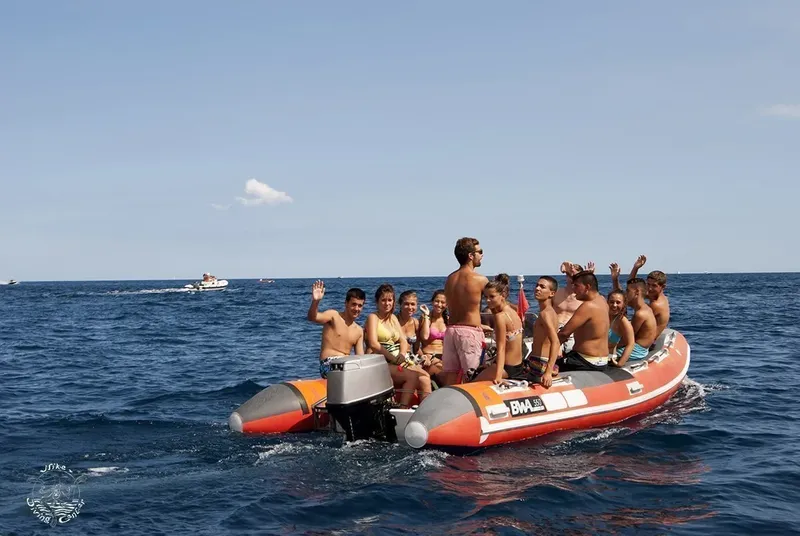 Groupe de personnes souriantes à bord d'un bateau pneumatique en mer