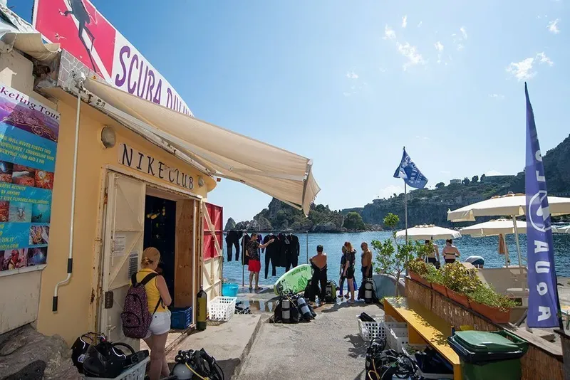 Devanture d'un centre de plongée avec du matériel et des personnes