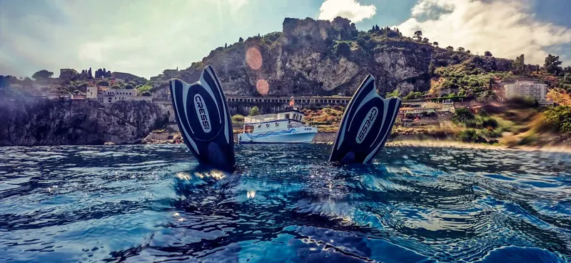 Paire de palmes de plongée en vue sous-marine avec bateau au loin