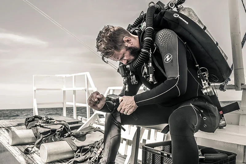 Plongeur préparant son équipement sur le pont d'un bateau de plongée