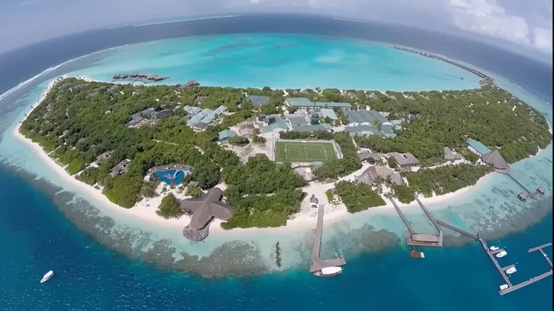 Vue aérienne d'une île tropicale avec bâtiments, plage et pontons