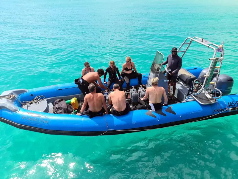 Groupe de personnes à bord d'un bateau pneumatique bleu turquoise