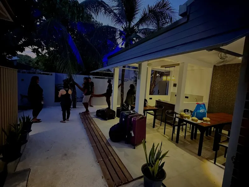 Personnes se tenant près d'un bâtiment ouvert avec des tables et des chaises